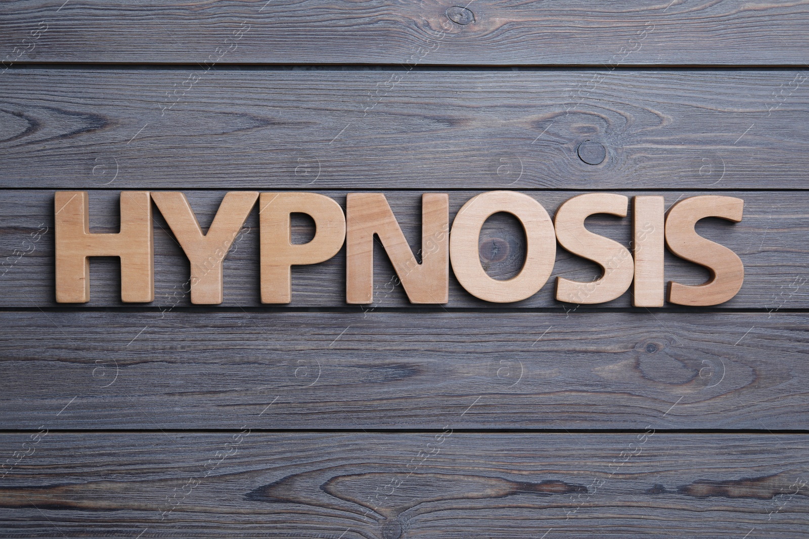 Photo of Word HYPNOSIS on wooden background, flat lay