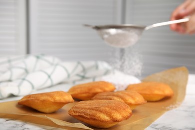 Delicious madeleine cakes on white marble table, closeup