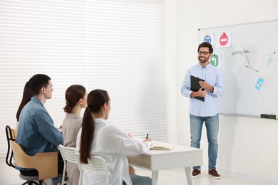 Photo of Teacher giving lesson to audience in driving school