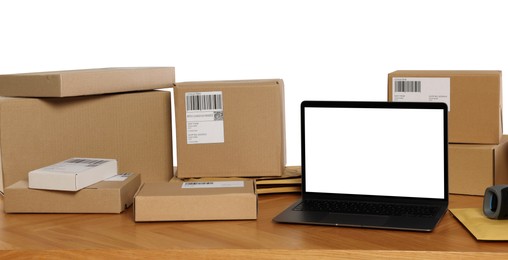 Photo of Different parcels and laptop on wooden table against white background. Online store
