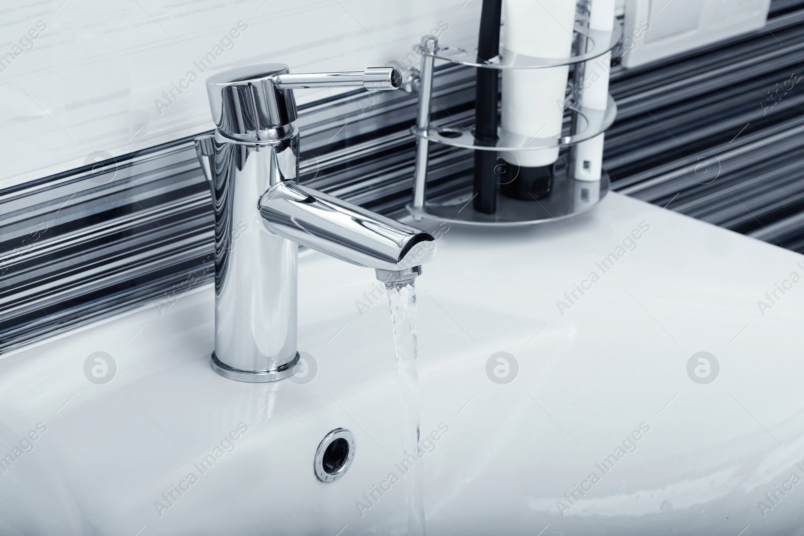 Photo of Stream of water flowing from tap in bathroom