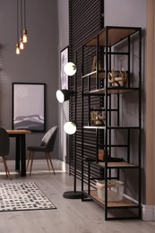 Photo of Stylish shelving unit with decor near grey wall indoors. Interior design