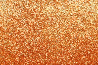 Image of Beautiful shiny orange glitter as background, closeup