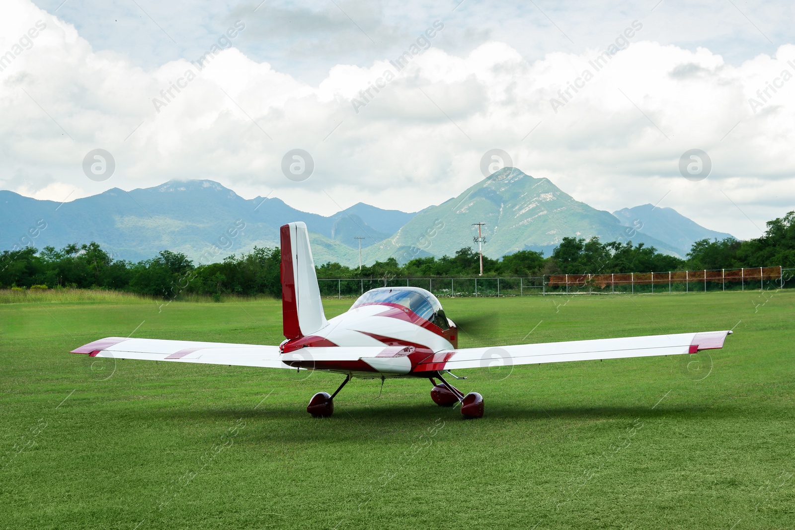 Photo of Modern airplane on green grass against mountains background