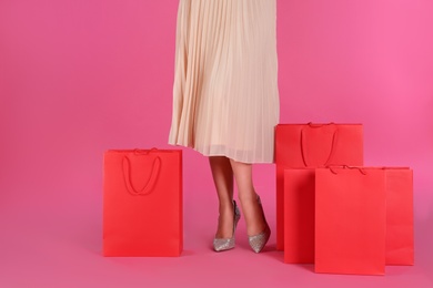 Woman with shopping bags on pink background, closeup. Black Friday Sale