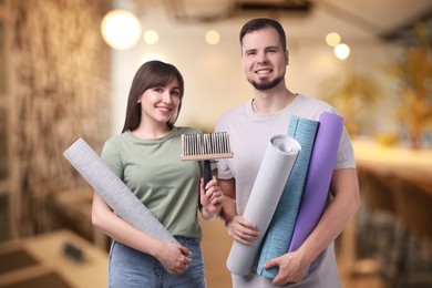Couple with wallpaper rolls and brush on blurred background