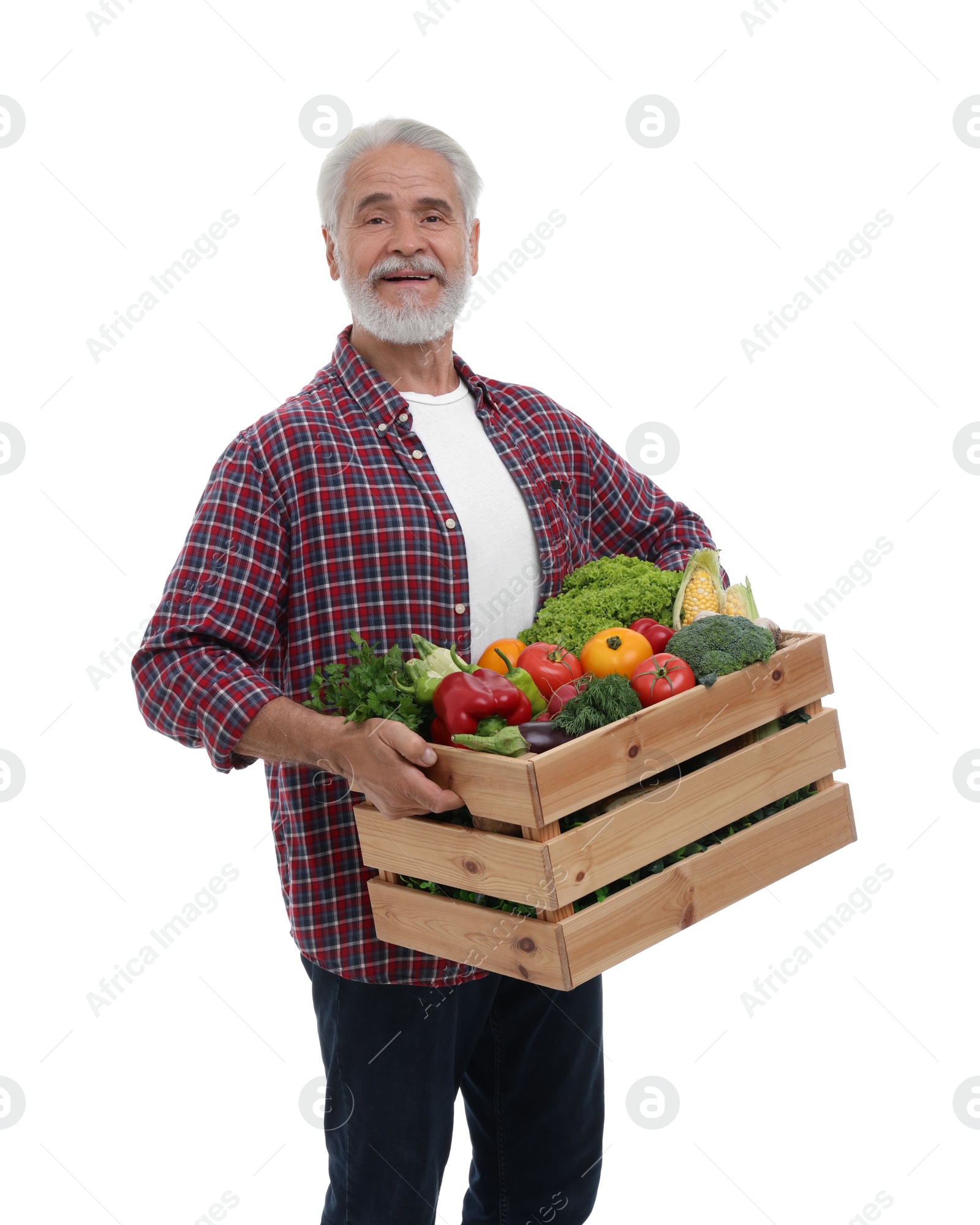 Photo of Harvesting season. Happy farmer holding wooden crate with vegetables on white background