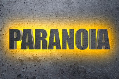 Image of Mental disorder. Illuminated word Paranoia on grey stone background