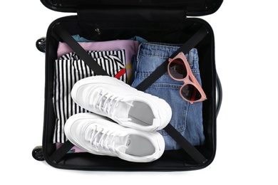 Photo of Open suitcase packed for travelling on white background, top view