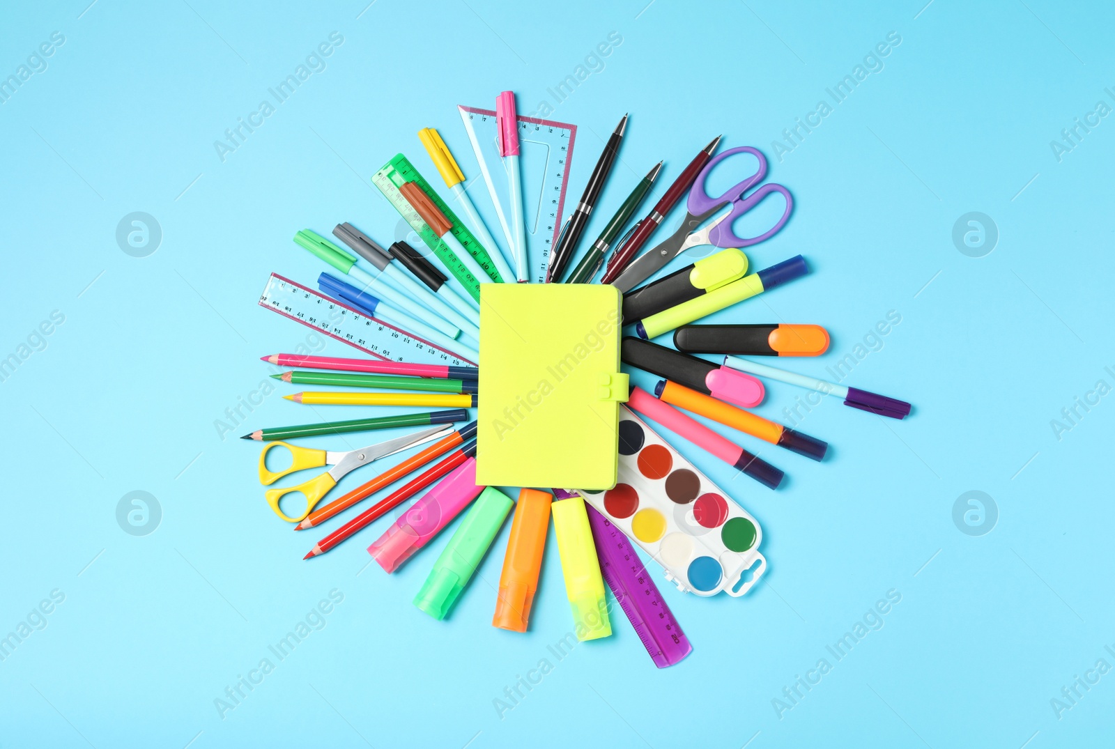 Photo of Different stationery and notebook on light blue background, top view. Back to school