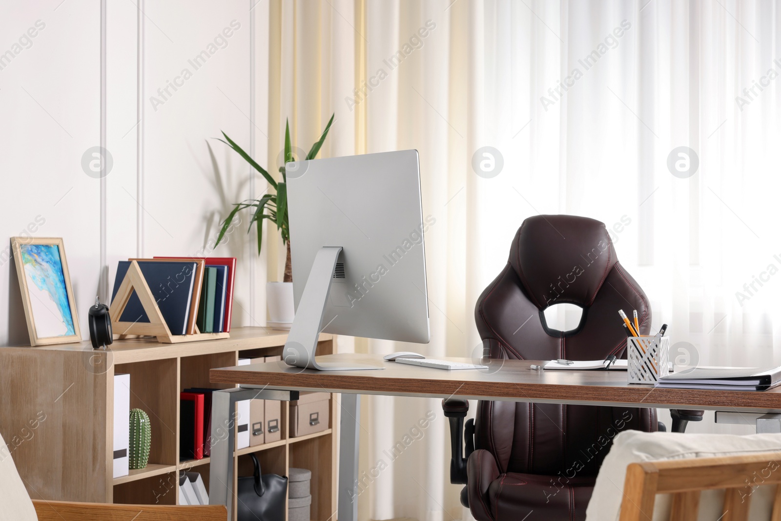Photo of Receptionist workplace with computer and waiting area. Interior design