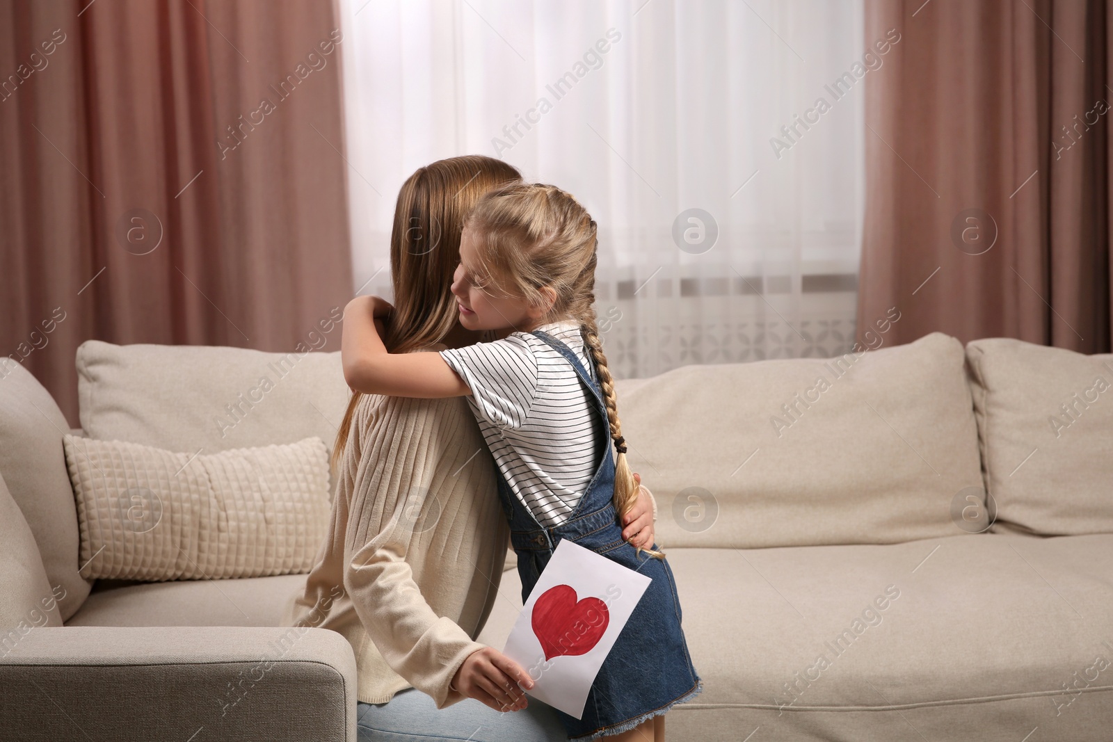 Photo of Little daughter congratulating her mom at home. Happy Mother's Day