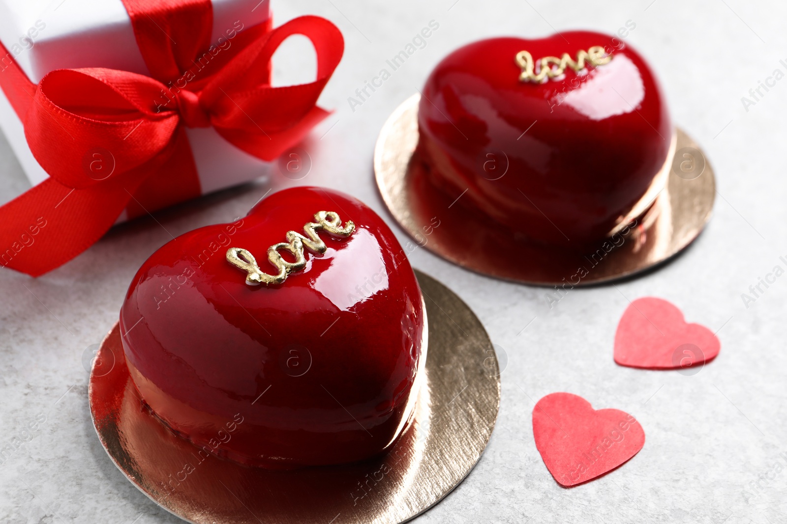 Photo of St. Valentine's Day. Delicious heart shaped cakes and gift on light table, closeup