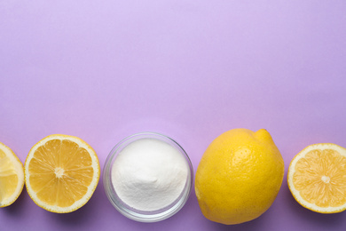 Photo of Baking soda and lemons on lilac background, flat lay. Space for text