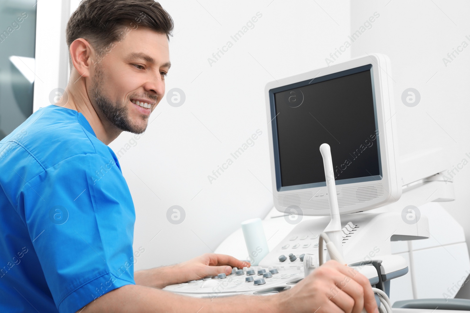 Photo of Professional sonographer using modern ultrasound machine in clinic