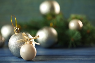 Photo of Beautiful Christmas balls on table against blurred background. Space for text