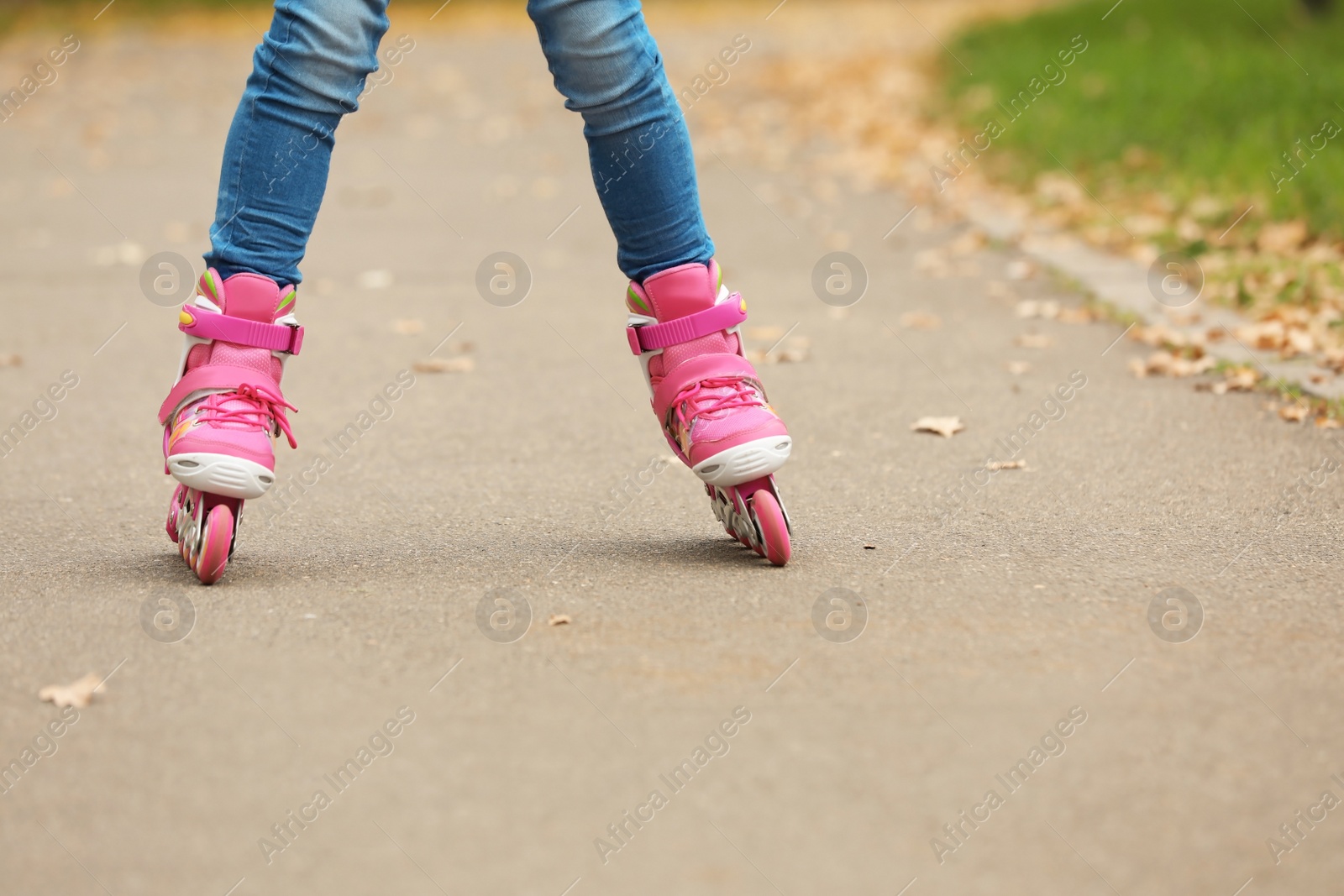 Photo of Cute girl roller skating in autumn park, focus on legs. Space for text