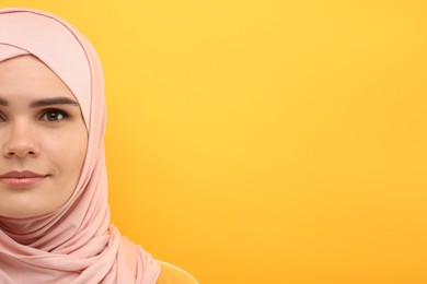 Photo of Muslim woman in hijab on orange background, space for text