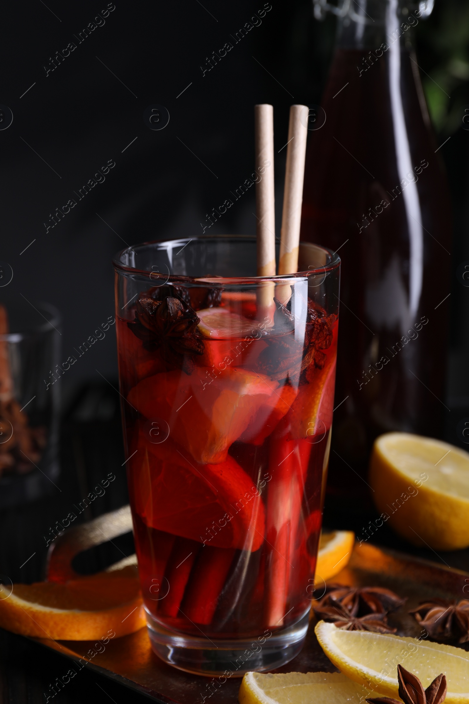 Photo of Glass of aromatic punch drink and ingredients on table