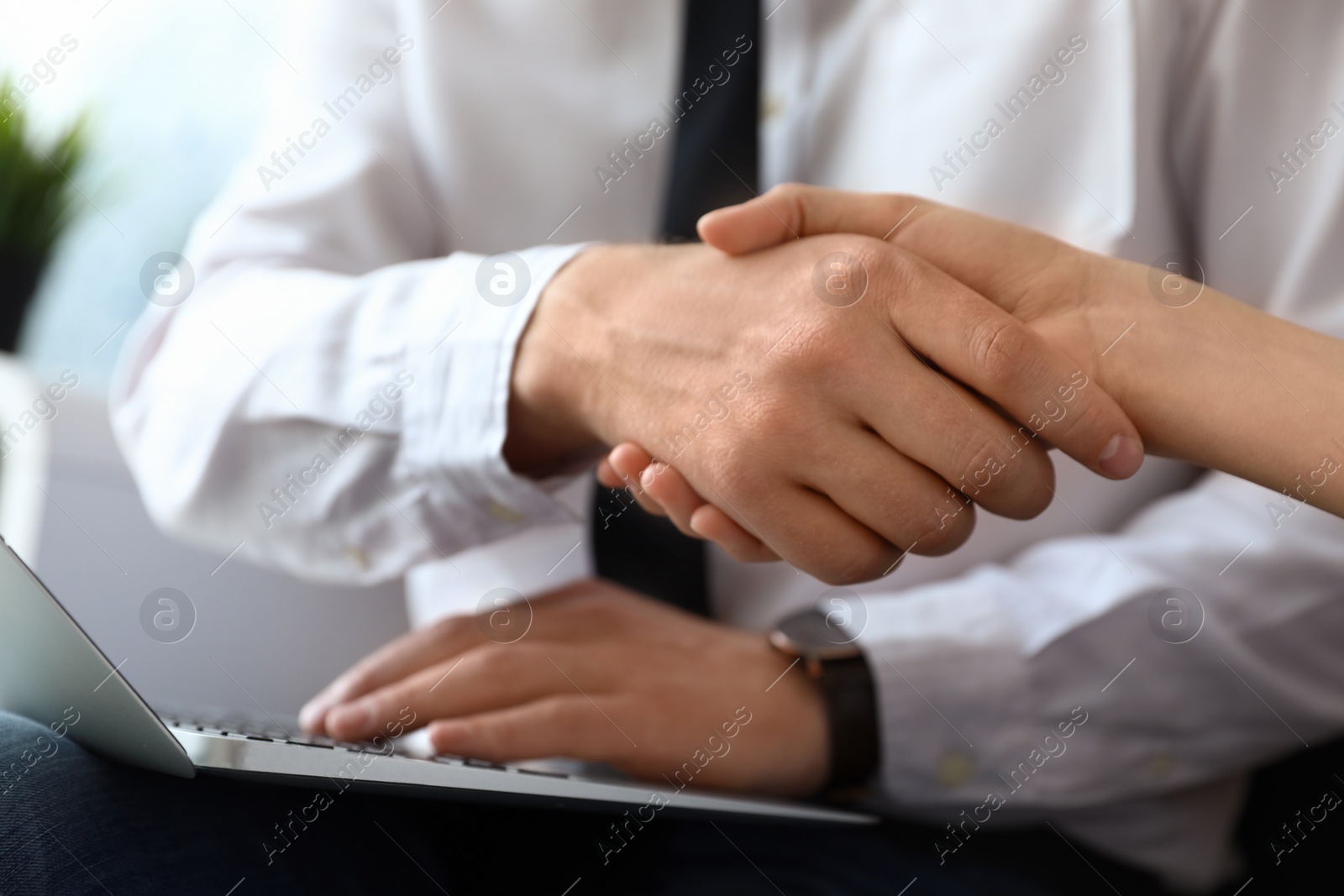 Photo of Business partners shaking hands after meeting, closeup