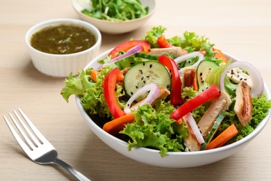 Photo of Delicious fresh chicken salad served on wooden table, closeup