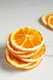 Dry orange slices on white table, closeup