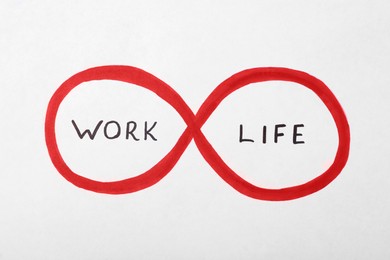 Photo of Infinity sign with words Work and Life on white background. Balance concept