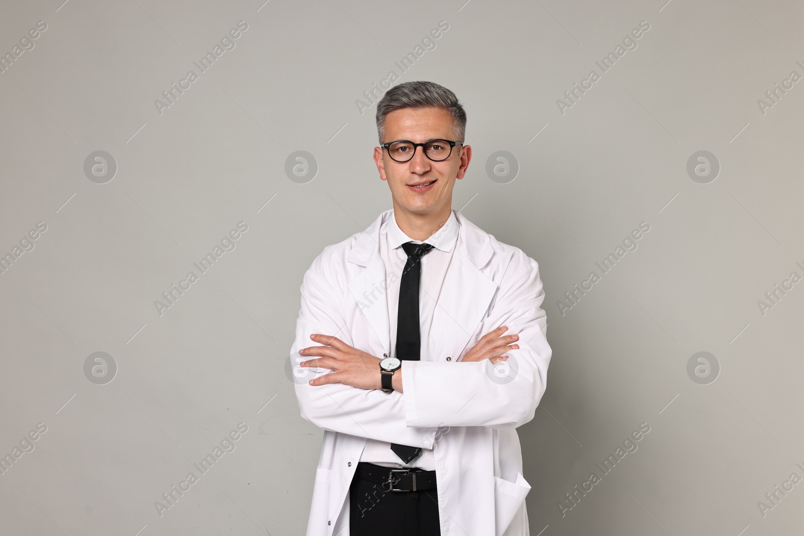 Photo of Happy doctor in glasses on grey background