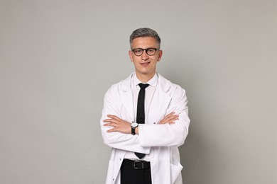 Happy doctor in glasses on grey background