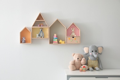House shaped shelves and chest of drawers with toys in children's room. Interior design