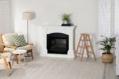 Photo of Wooden folding ladder near fireplace in stylish room