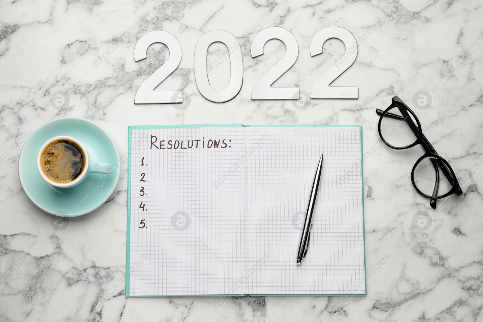 Photo of Making resolutions for 2022 New Year. Flat lay composition with notebook on white marble table