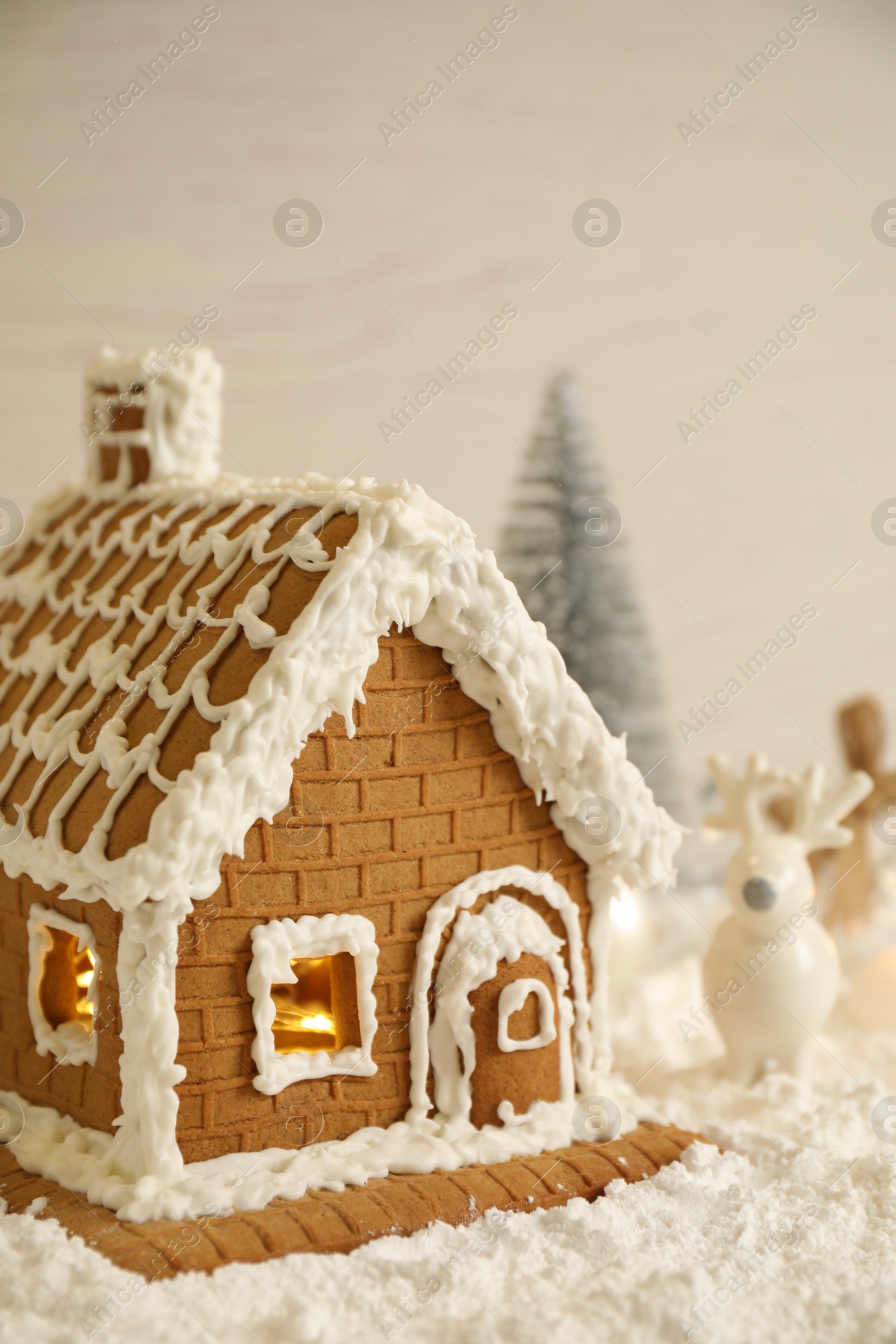 Photo of Beautiful gingerbread house decorated with icing on snow