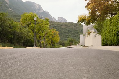 Photo of Picturesque view of road and green trees near mountains