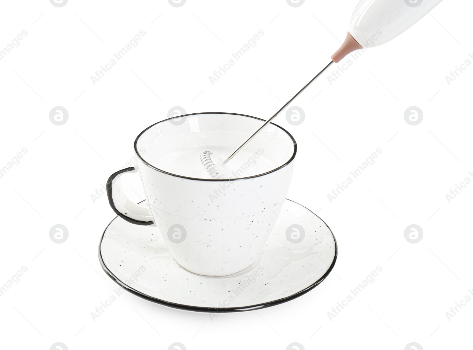 Photo of Whisking milk in cup with mini mixer (frother wand) isolated on white