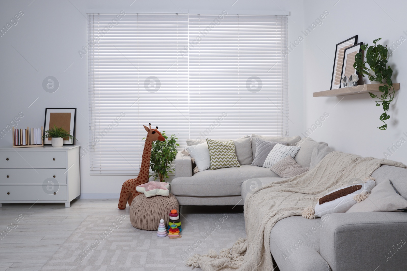 Photo of Stylish child room with comfortable sofa and toys. Interior design