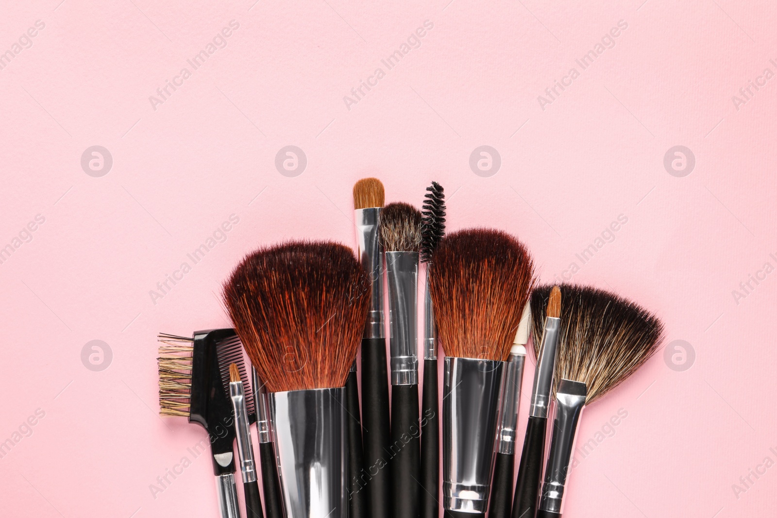 Photo of Different makeup brushes on pink background, flat lay. Space for text