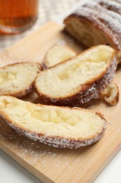 Pieces of delicious yeast dough cake on wooden board, closeup