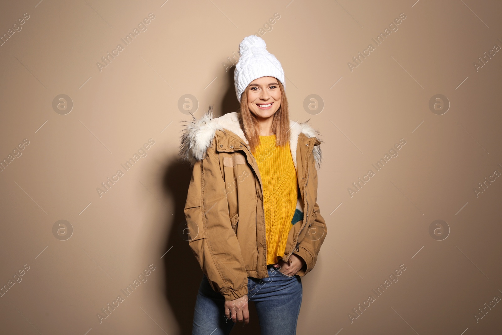 Photo of Young woman wearing warm clothes on color background. Ready for winter vacation