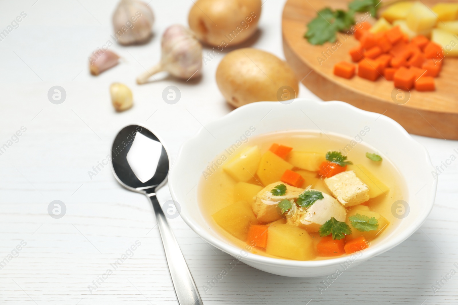 Photo of Dish with fresh homemade chicken soup on wooden table, space for text