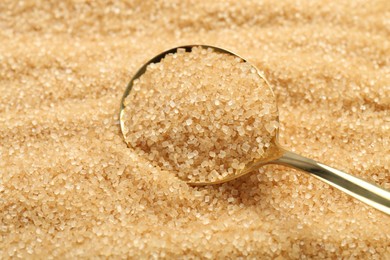 Photo of Spoon on granulated brown sugar, closeup view