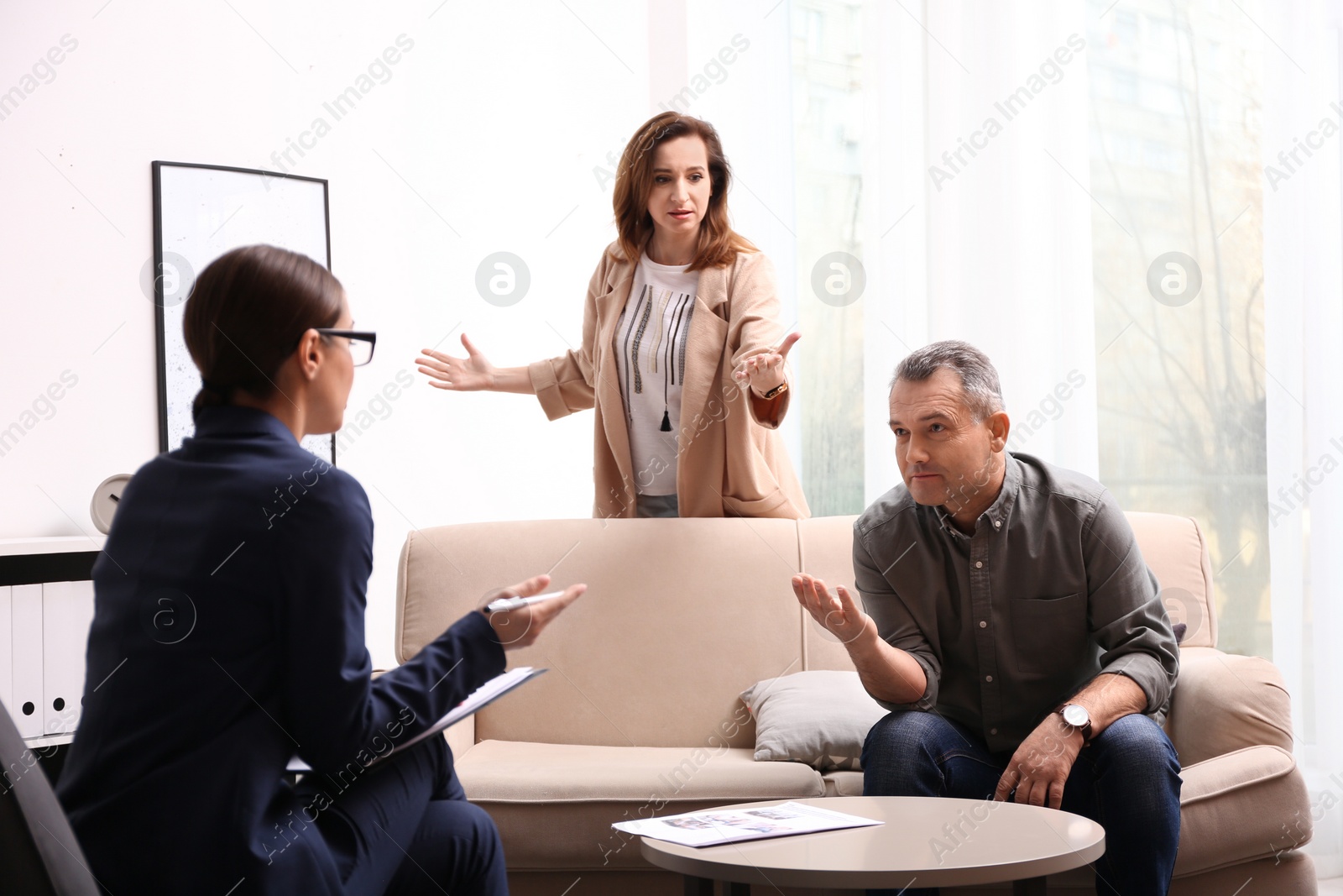 Photo of Psychotherapist working with couple in office. Family counselling