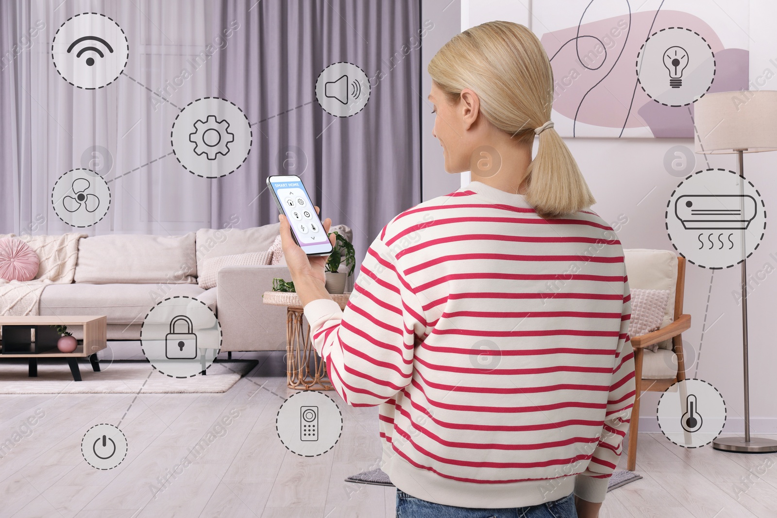 Image of Woman using smart home control system via application on mobile phone indoors. Different icons around her