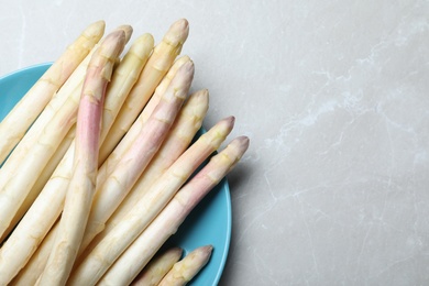 Photo of Fresh white asparagus on grey marble table, top view. Space for text