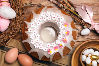 Photo of Flat lay composition of delicious Easter cake decorated with sprinkles on wooden table