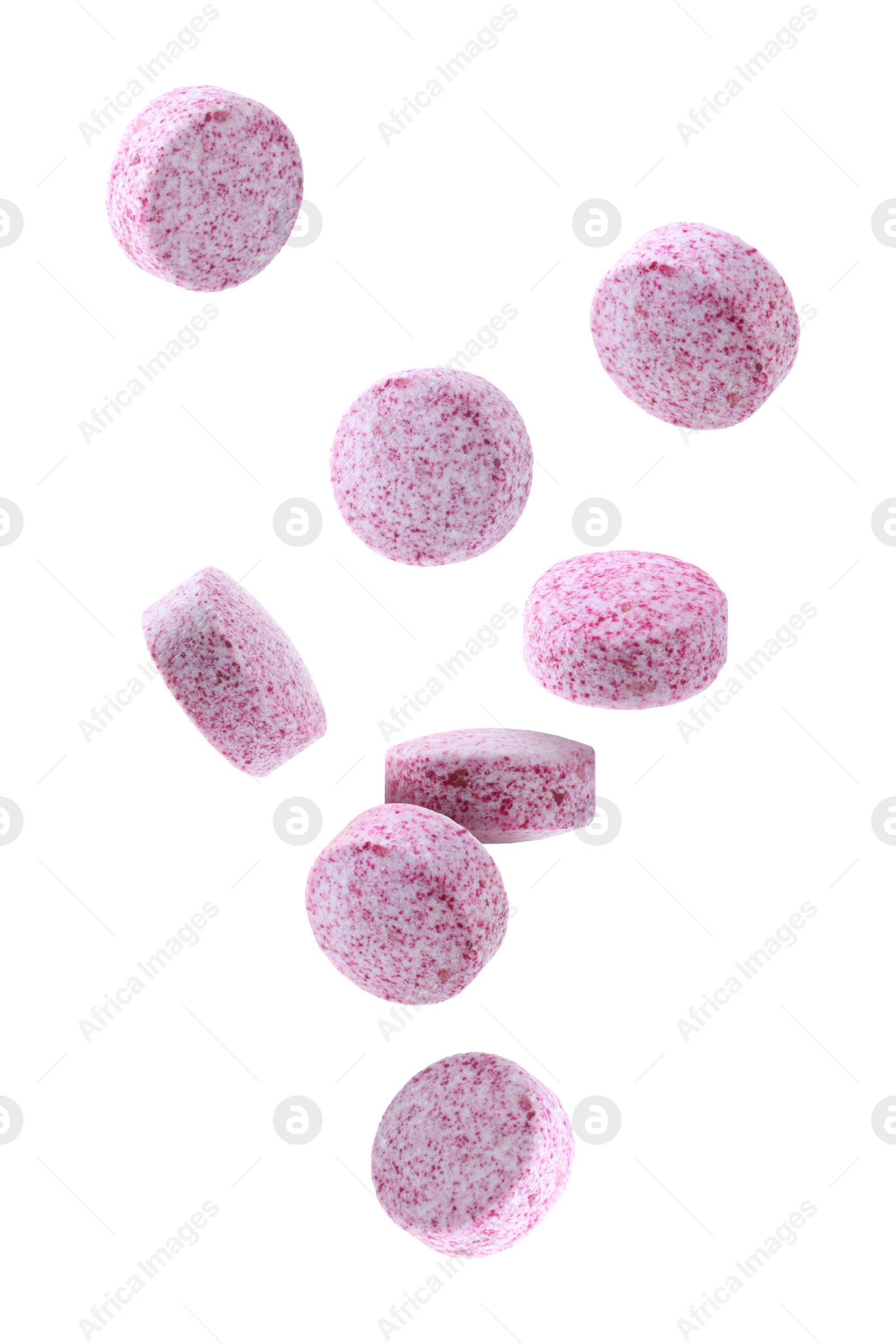 Image of Vitamin. Pink tablets falling on white background