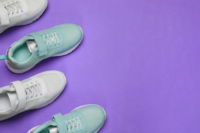 Different stylish sports shoes on violet background, flat lay. Space for text