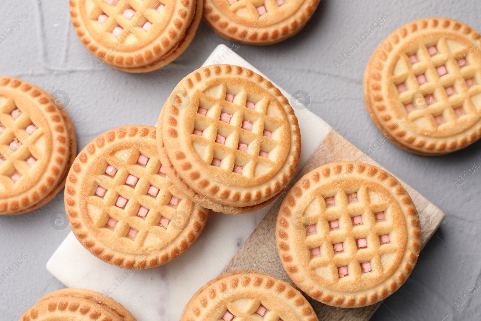 Photo of Tasty sandwich cookies with cream on light grey table, flat lay