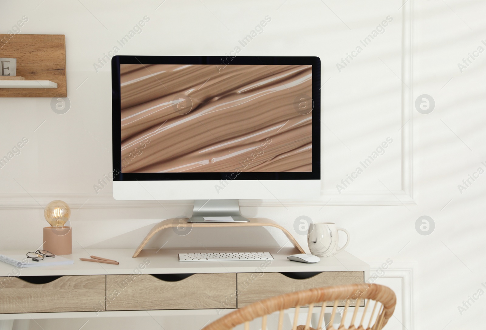 Photo of Comfortable workplace with modern computer and lamp in room. Interior design