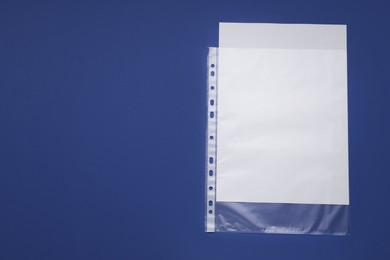 Photo of Punched pocket with paper sheet on blue background, top view. Space for text